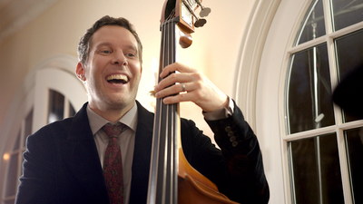 Alegria male upright bass player performing live for guests in a ballroom