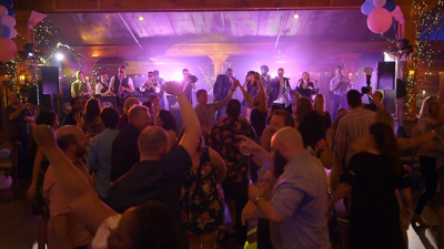 Revel Arcade guests dance and band plays on stage at wedding venue